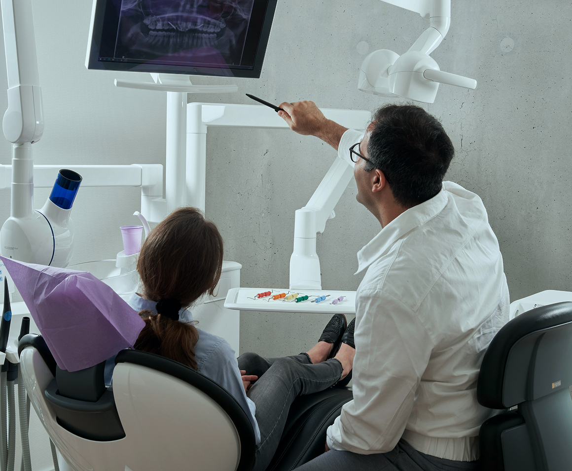Um dentista mostrando um raio-x para uma paciente